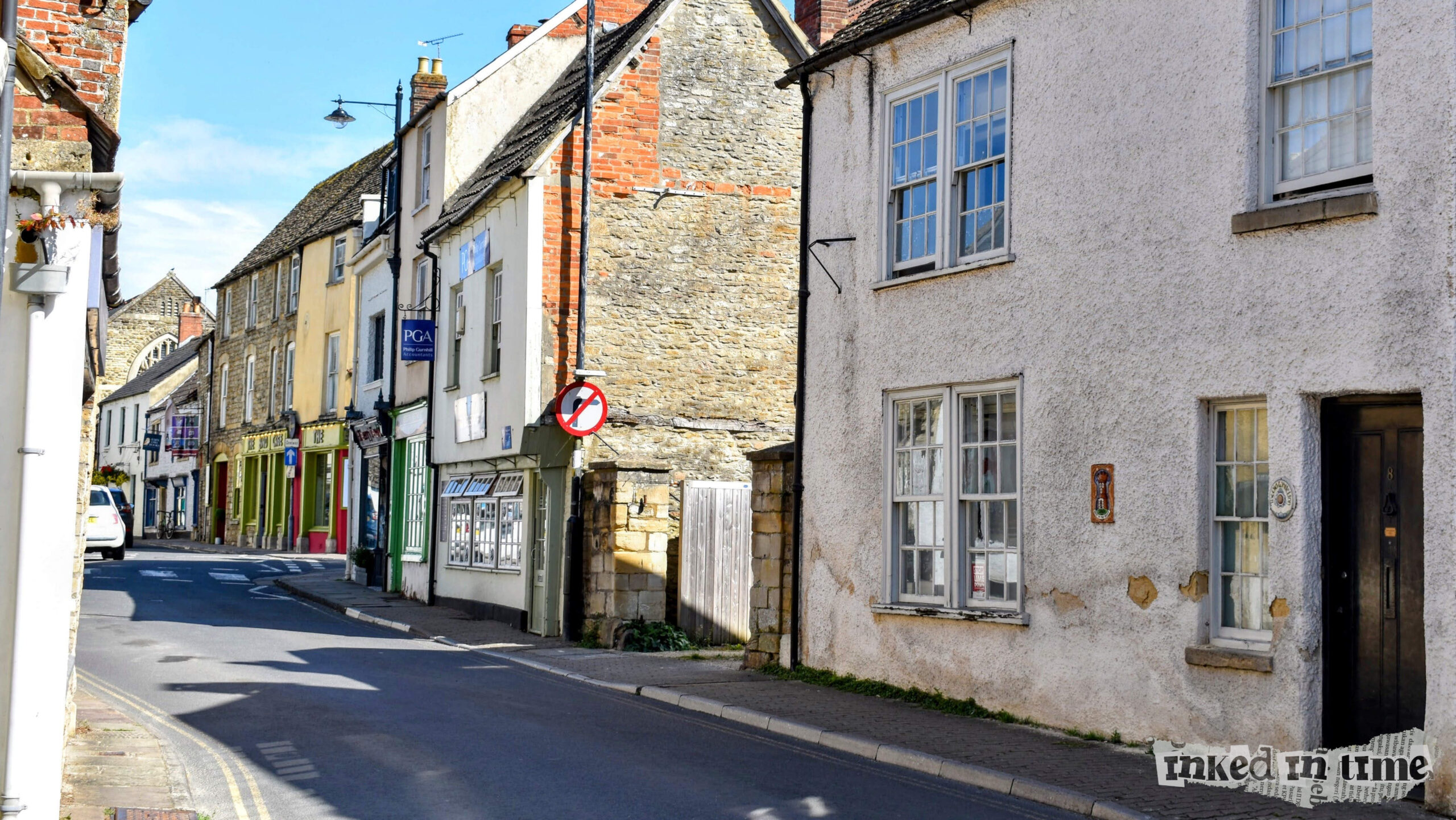 A view of the premises formerly occupied by the White Lion in Malmesbury, on the right-hand side of the image. The view looks towards the exit from the High Street, and towards Oxford Street.